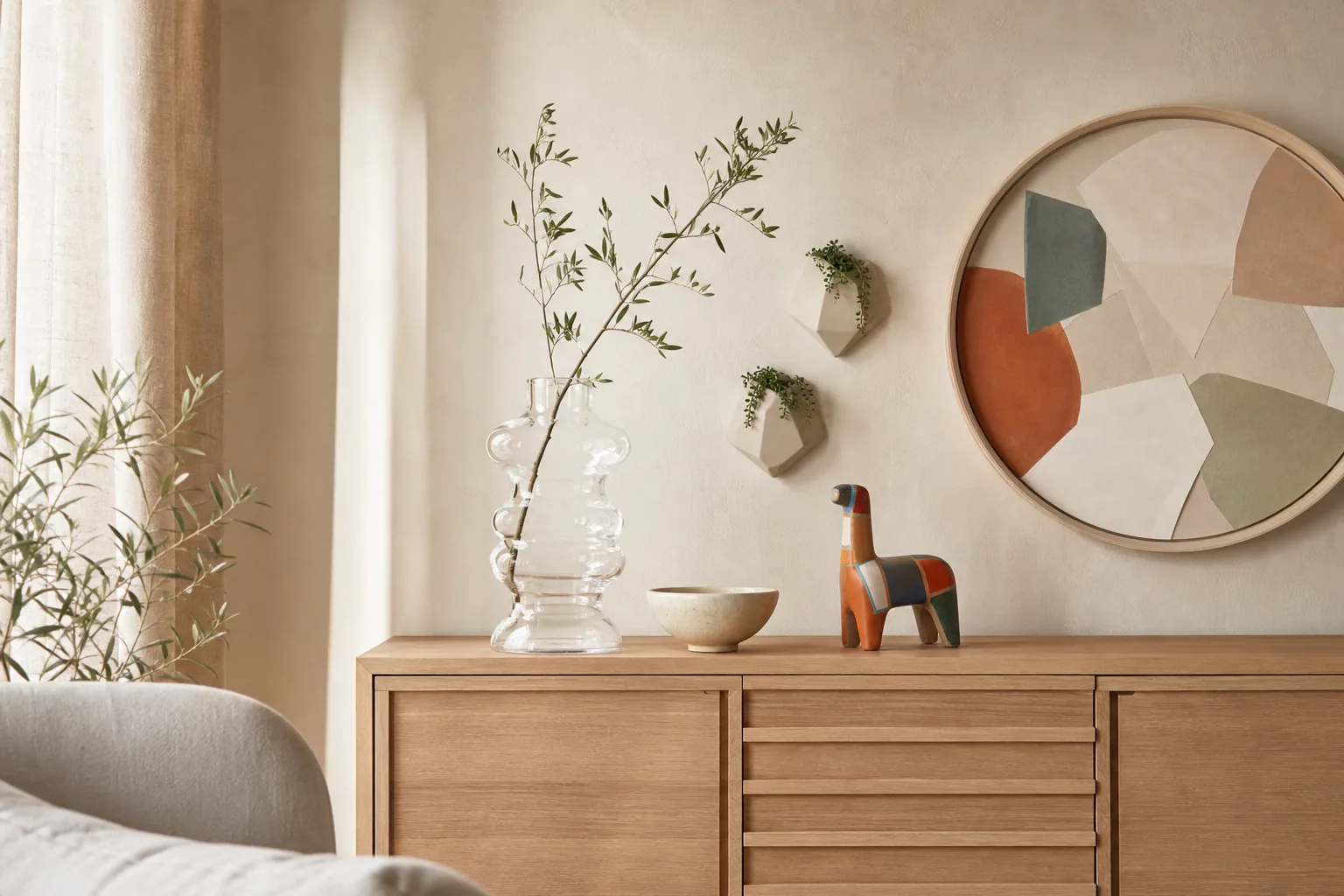 Ruhig dekoriertes Sideboard mit Vase, Kunstobjekt und Pflanze